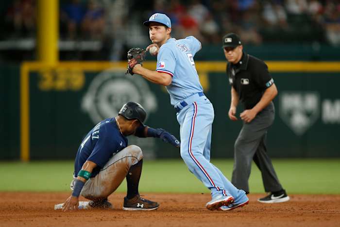 Jul 17, 2022; Arlington, Texas, USA; Texas Rangers shortstop Corey Seager (5) turns a double play as Seattle Mariners center fielder Julio Rodriguez (44) slides into second base in the third inning at Globe Life Field. Mandatory Credit: Tim Heitman-USA TODAY Sports